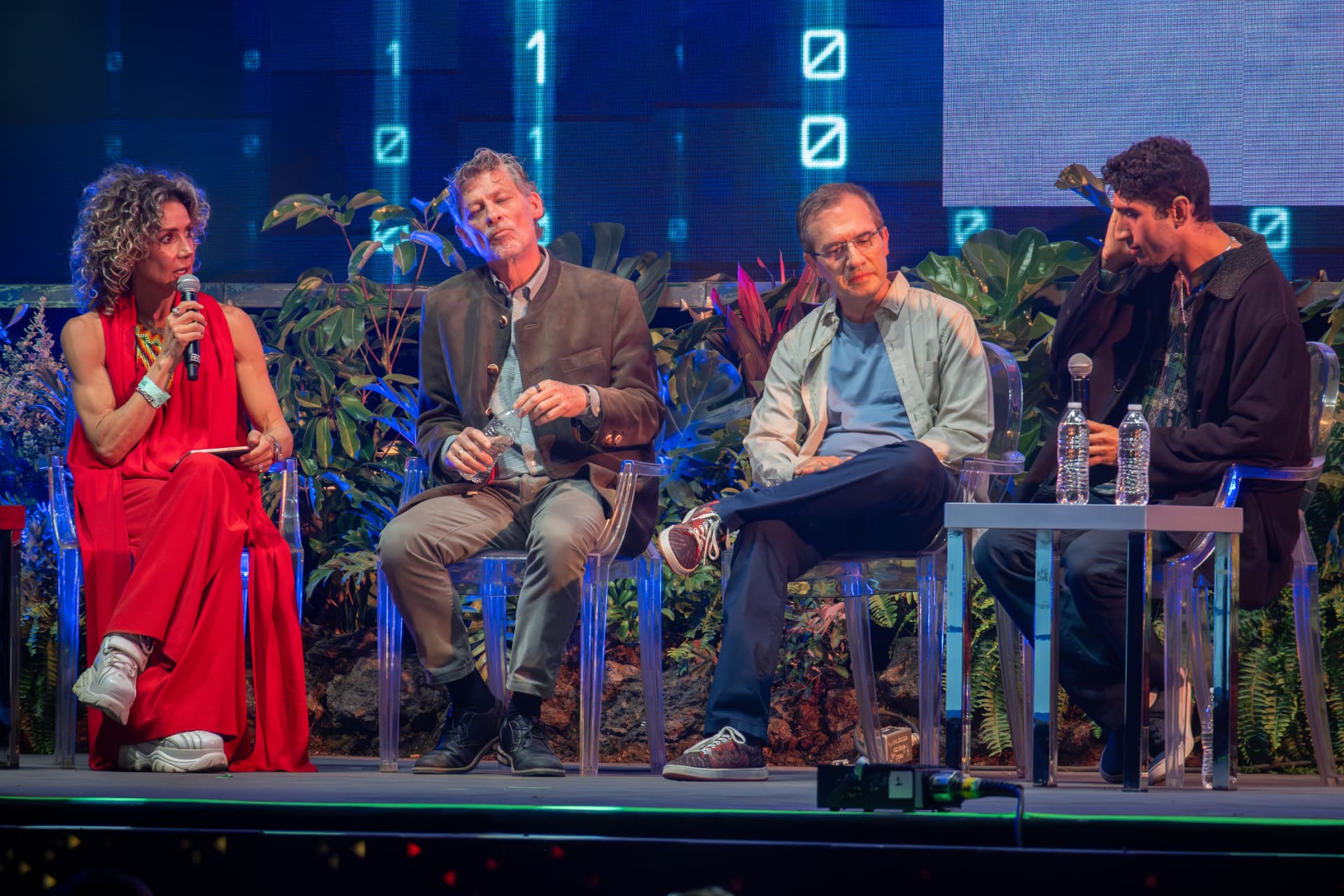Panel de especialistas conversando en el escenario de Qualia